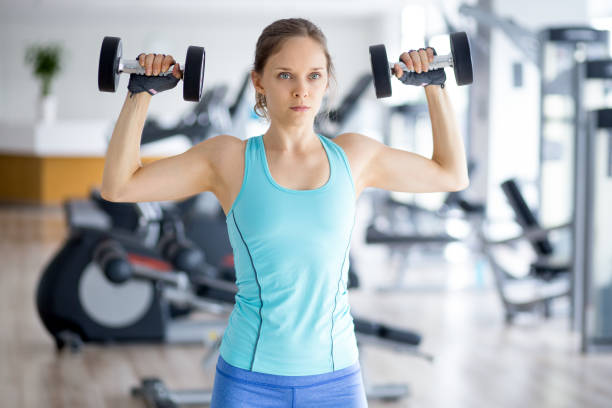 istock Serious Woman Training With Dumbbells in Gym 683900894