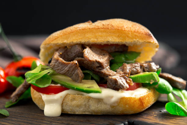 istock Fresh burger with beef grilled, tomato and avocado on wooden board 683904532