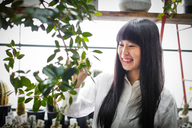 istock Happy young Japanese female worker working in a flower shop 683907856
