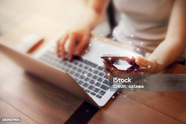 Woman Hand Using Mobile Phone And Laptop Worldwide Connection Technology Interface Stock Photo - Download Image Now