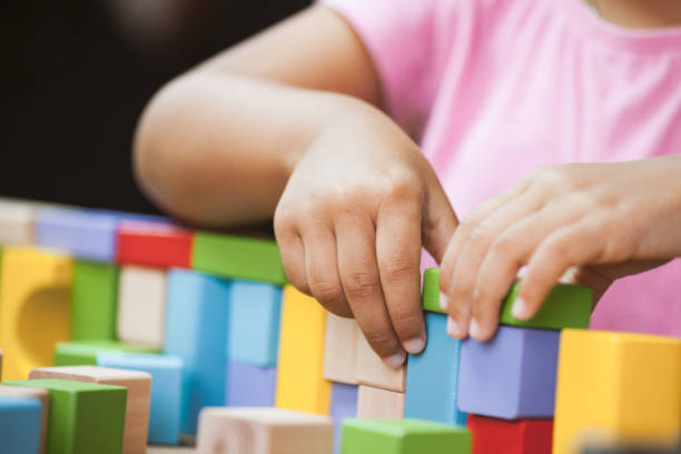 istock Focus on child's hand  playing with colorful wooden blocks 683908148