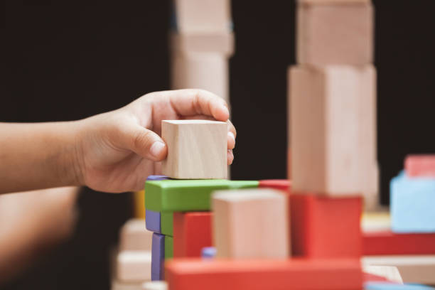 istock Focus on child's hand  playing with colorful wooden blocks 683908314