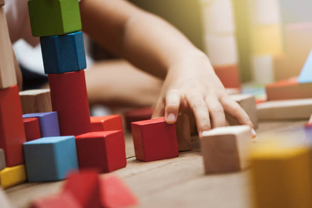 istock Focus on child's hand  playing with colorful wooden blocks 683908324