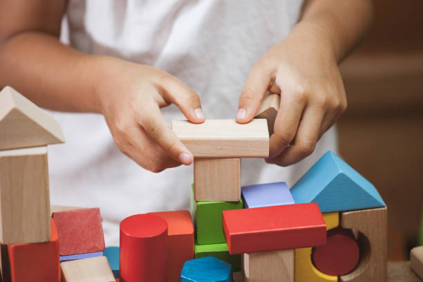 istock Focus on child's hand  playing with colorful wooden blocks 683910654