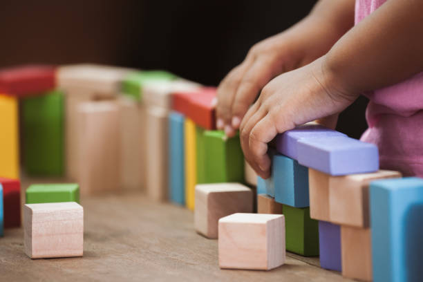 istock Focus on child's hand  playing with colorful wooden blocks 683910672