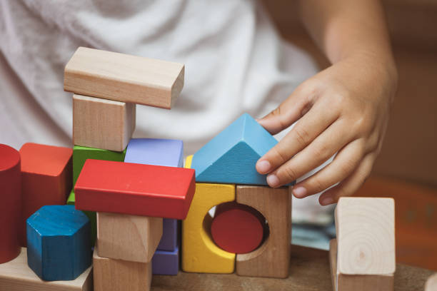 istock Focus on child's hand  playing with colorful wooden blocks 683910774