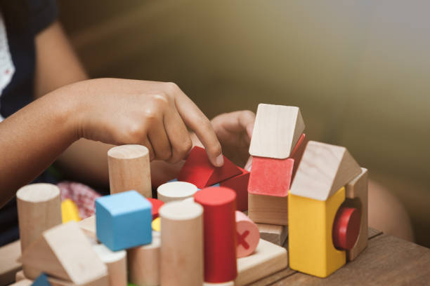 istock Focus on child's hand  playing with colorful wooden blocks 683911030