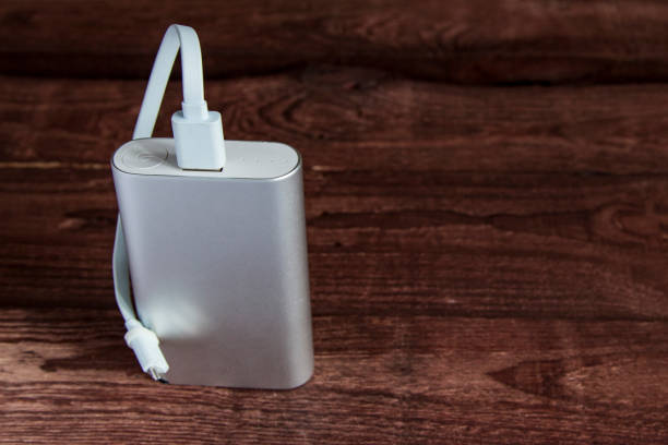 Grey Portable External Battery ( Powerbank ) On A Wooden Table .