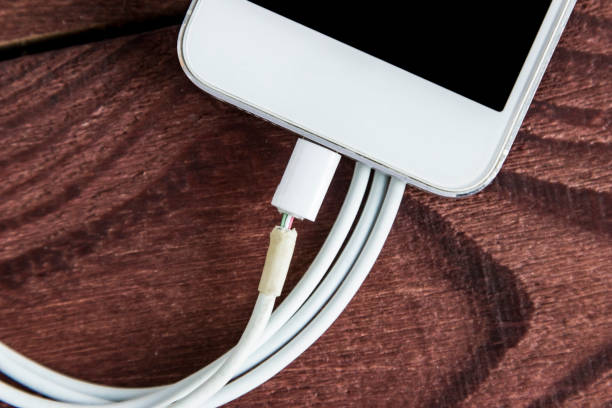 Broken Charging Cable With Phone  On A Wooden Background