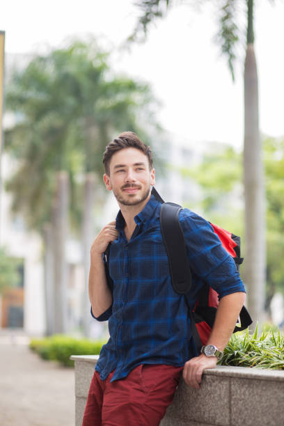 istock Dreamy Handsome Man Sitting on Flowerbed in City 683911886
