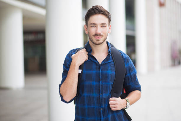 inhalt hübscher junger mann mit rucksack in stadt - mature student stock-fotos und bilder