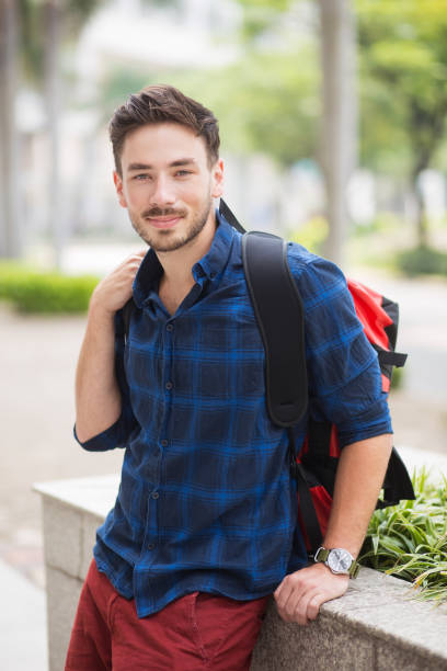 istock Positive Handsome Traveler Sitting on Flowerbed 683911904