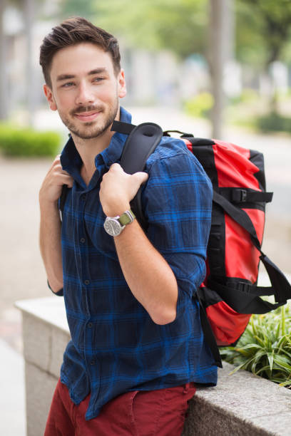 istock Positive Handsome Guy Sitting on Flowerbed in City 683911912