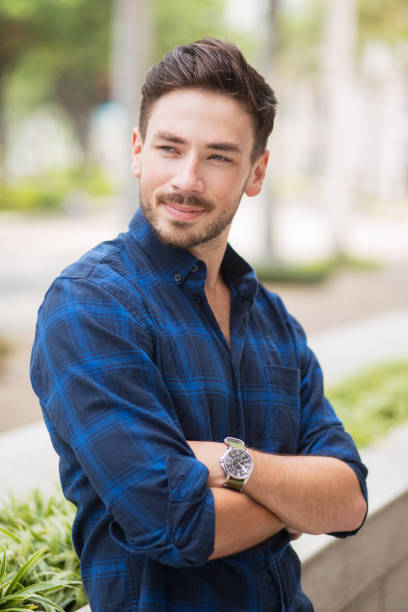 istock Smiling Handsome Guy Leaning on Flowerbed in City 683911944