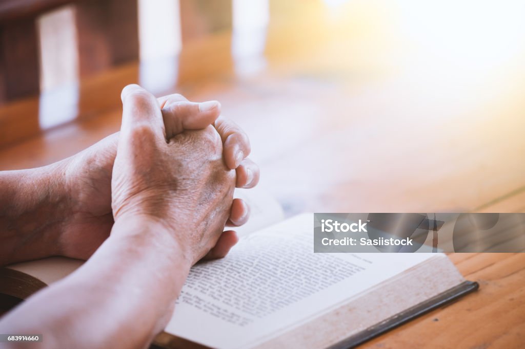 Ältere Frau Hände gefaltet im Gebet auf eine Bibel - Lizenzfrei Beten Stock-Foto