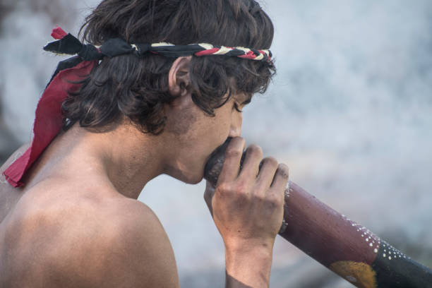 jovem joga o didgeridoo no desfile de mardi grass. - aborigine didgeridoo indigenous culture australia - fotografias e filmes do acervo