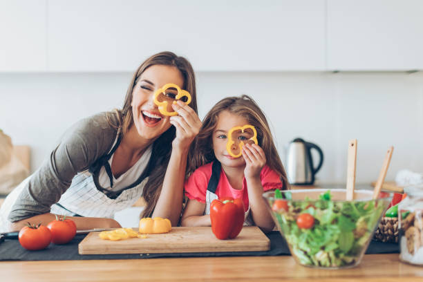 istock Mother and daughter looking through pepper slices 683933436