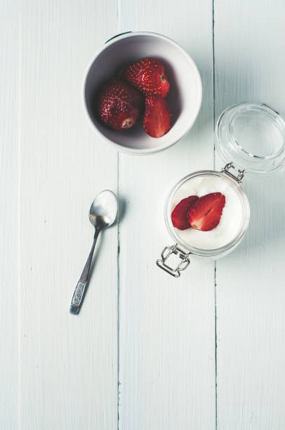 erdbeer-joghurt und beeren in gläser auf weißem hintergrund aus holz - berry fruit refreshment rural scene vertical stock-fotos und bilder