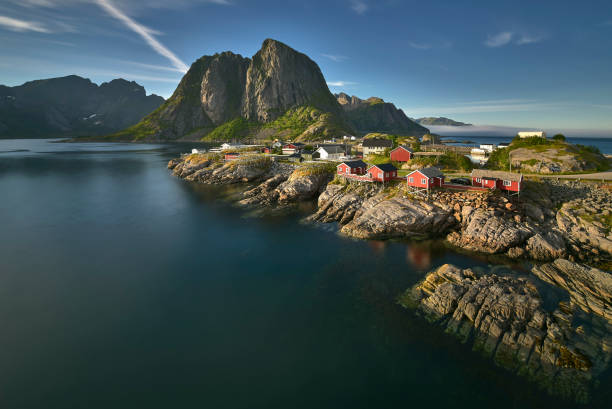 fiordo panoramico sulle isole lofoten, con tipico rifugio rosso e imponenti cime montuose, hamnoy, norvegia - arch rock foto e immagini stock