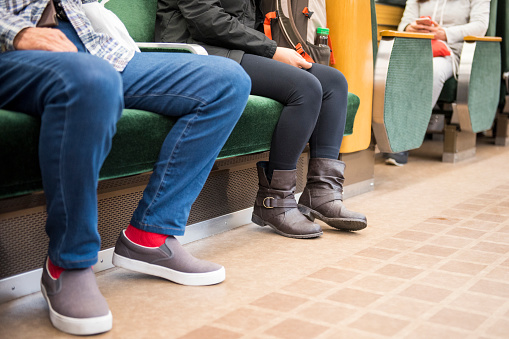 feet of passenger on train in tokyo metro commuter ground view,low section of public transport passengers.