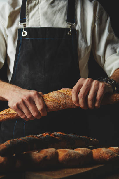 Hand breaks baguette