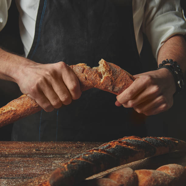 Male hands break the baguette