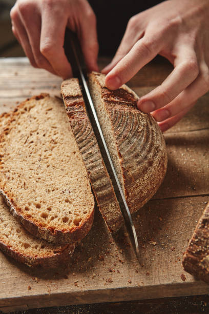 istock Male hands slicing homemade bread 683944792