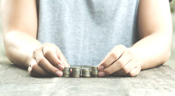 human with stack of coins vintage light stock photo