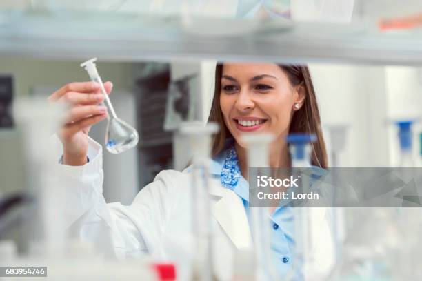 Woman Scientist Studying Chemical Liquid In Lab Flask Scientist Carrying Out Experiment In Research Laboratory Stock Photo - Download Image Now