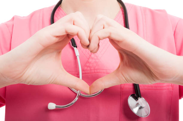 Close-up of female nurse showing heart shape stock photo