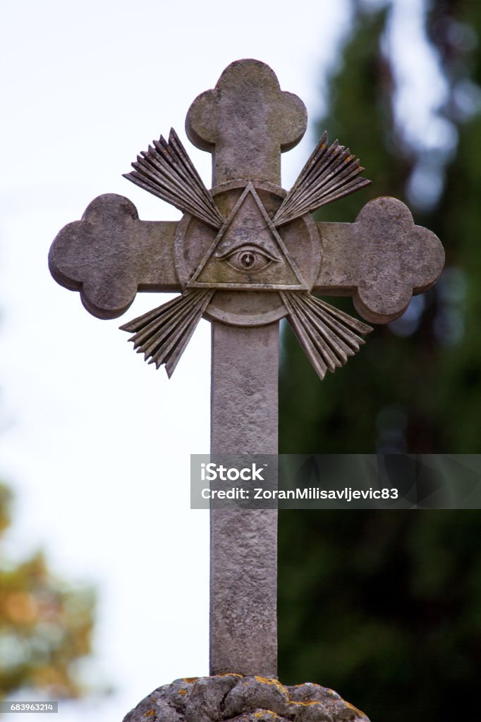 Part of stone cross with masonic motives on the grave, monument in cemetery, close up. Sculpture art. Freemasons Stock Photo