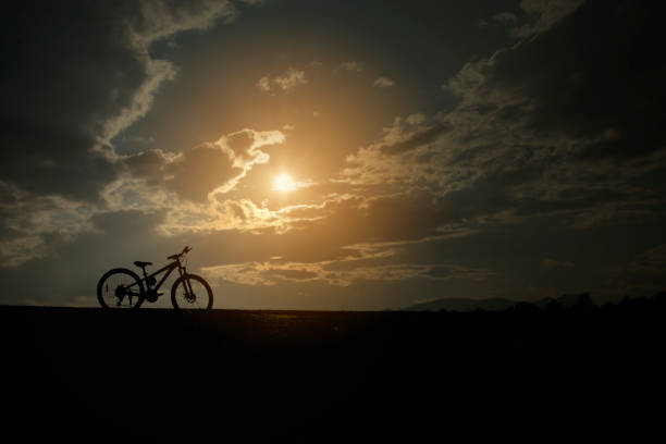 istock Silhouette sport bicycle with beautiful sun sky romance view background 683963498