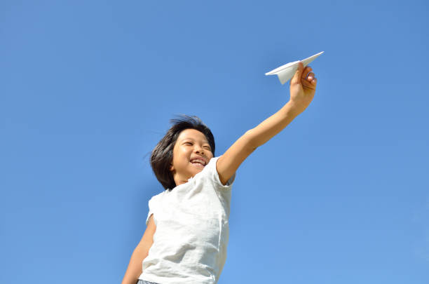 boy flying his plane in sunflower field