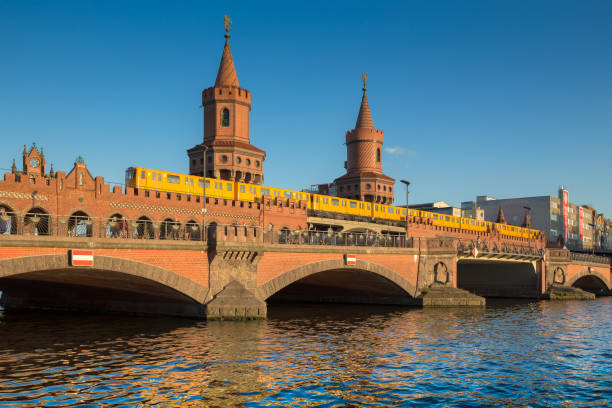 Oberbaum Bridge with Spree river at sunset, Berlin, Germany Classic panoramic view of famous Oberbaum Bridge with historic Berliner U-Bahn crossing the Spree river on a beautiful sunny day with blue sky in summer, Berlin, Germany friedrichshain photos stock pictures, royalty-free photos & images