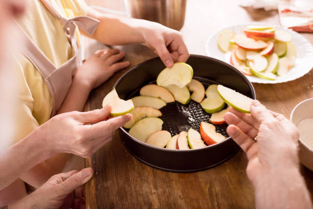 アップルパイを焼く家族 - grandmother pie cooking baking ストックフォトと画像