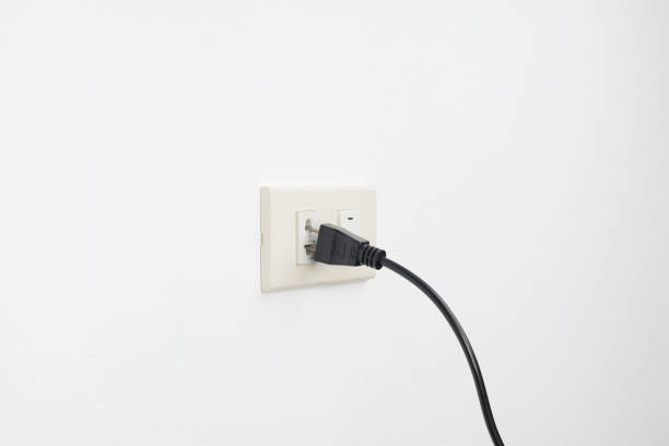 istock Loose plug and falling from outlet electric shock on white wall background, check and safety electricity household concept 683973284