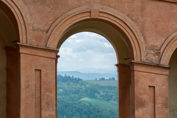 istock Green fields and cloudy sky in Italy, Bologna through archway 683973922