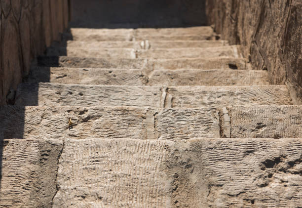 Closeup detail of stone paved steps on rural footpath walkway going downwards to blurred background