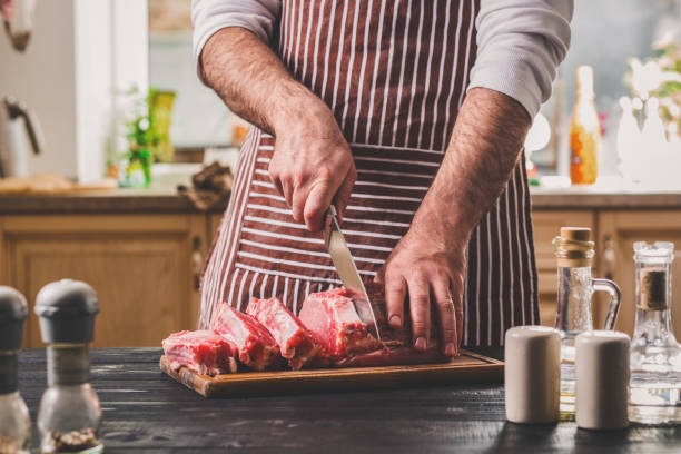 człowiek kawałki świeżego kawałka mięsa na drewnianej deski do krojenia w kuchni domowej - steak sirloin steak dinner healthy eating zdjęcia i obrazy z banku zdjęć