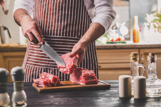 coupes homme de frais morceau de viande sur une planche à découper en bois dans la cuisine à domicile - chop cut of meat fillet food photos et images de collection