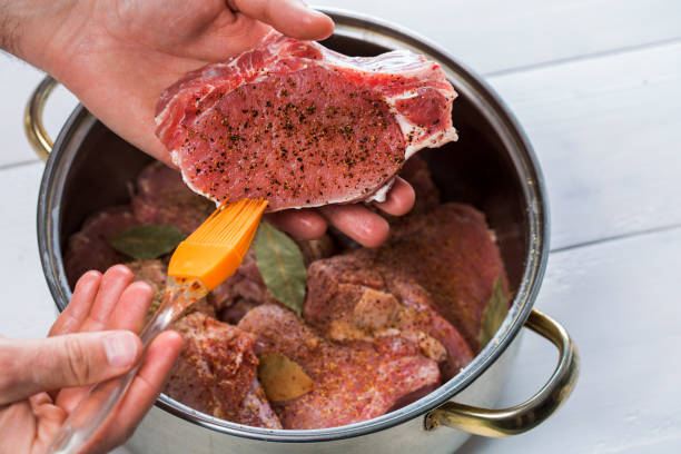 istock Close up of chefs hands spicing the meat 683988300