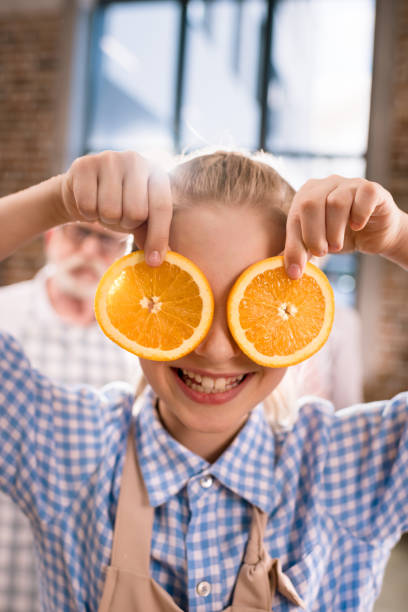 istock girl holding orange slices 683988406
