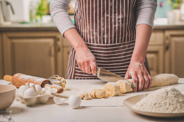 istock Close-up view of two woman's hands cut knife dough 683991042