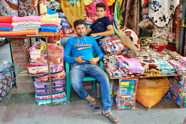 Two young Persian men trade textiles in the Grand Bazaar.
