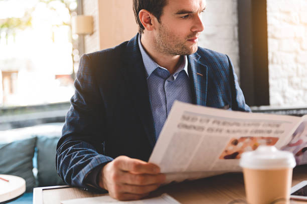 istock Serious businessman looking through news 683992760