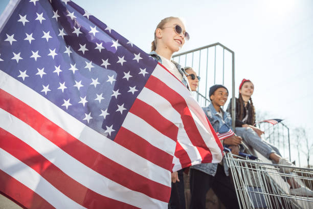 istock teenagers having fun and waving american flags 683993236