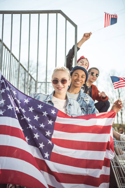 istock teenagers having fun and waving american flags 683997682