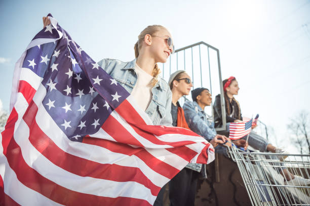istock teenagers having fun and waving american flags 683998070