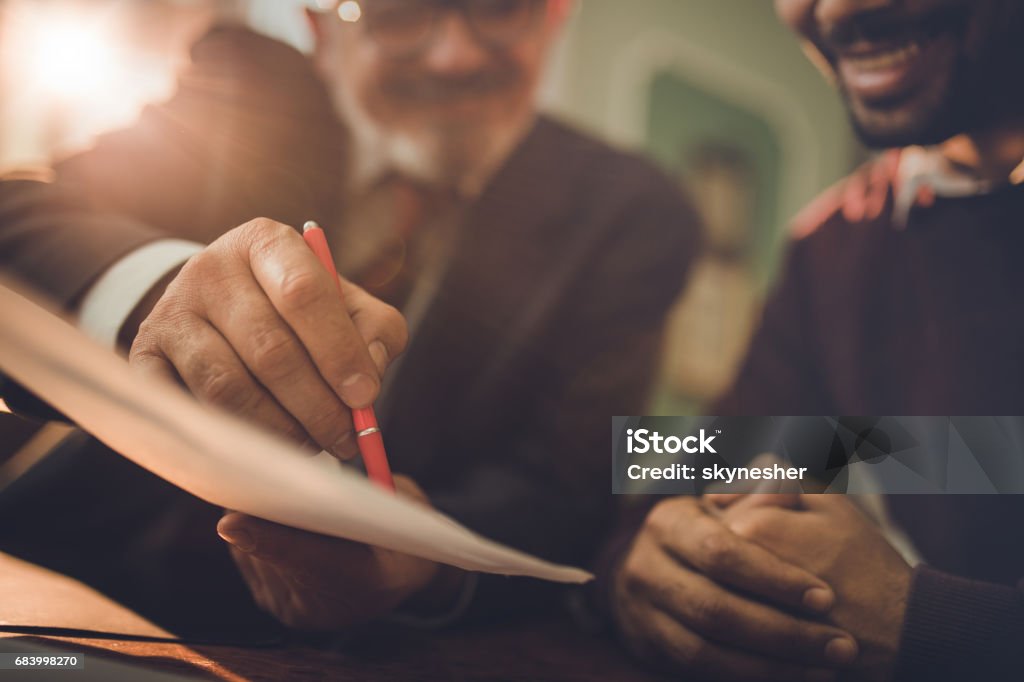 All you need is to sign right here! Close up of two businessmen about to sign a contract after successful agreement. Financial Loan Stock Photo
