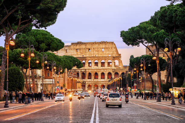 Traffic street in front of Colosseum, Rome, Italy Rome, Italy - April 04: Traffic on the Via dei Fori Imperiali street in front of Colosseum in the evening, Rome, Italy, on April 04, 2013 coliseum rome stock pictures, royalty-free photos & images